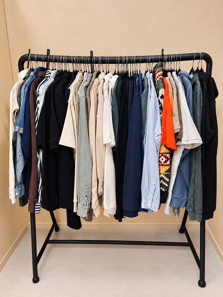 Rek met overhemden, shirts en truien